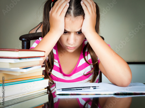 Photo: Angry and tired schoolgirl studying Angry and tired schoolgirl studying