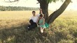 Vídeo: Young couple hugging below the tree on the meadow Young couple hugging below the tree on the meadow