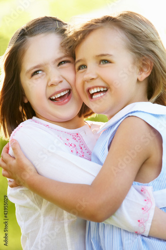 Photo: Two Young Girls Giving One Another Hug In Summer Field Two Young Girls Giving One Another Hug In Summer Field