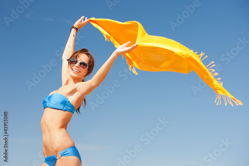 Photo: happy woman with yellow sarong on the beach happy woman with yellow sarong on the beach