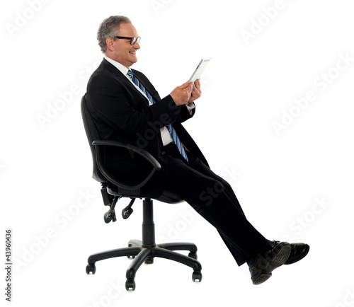Photo: Well dressed corporate male holding wireless tablet Well dressed corporate male holding wireless tablet