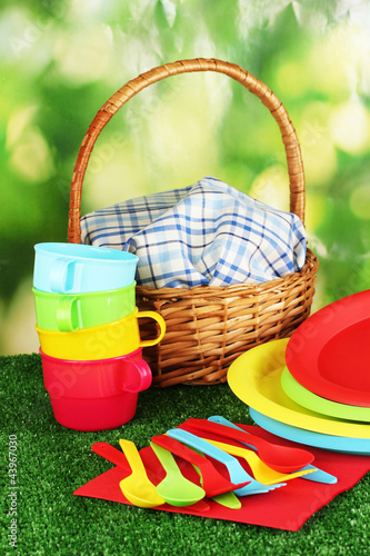 Photo: bright plastic disposable tableware and picnic basket bright plastic disposable tableware and picnic basket