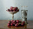 Cherries on a silver plate and an ancient glass