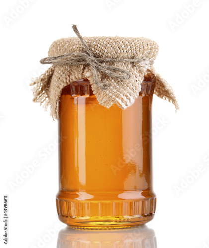 Photo: Sweet honey in jar isolated on white Sweet honey in jar isolated on white