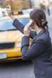 Photo: Young Woman on Cell Phone Hailing a Yellow Taxi Cab Young Woman on Cell Phone Hailing a Yellow Taxi Cab
