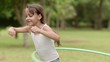 Video: Happy little girl playing hula hoop in park. Slow motion Happy little girl playing hula hoop in park. Slow motion