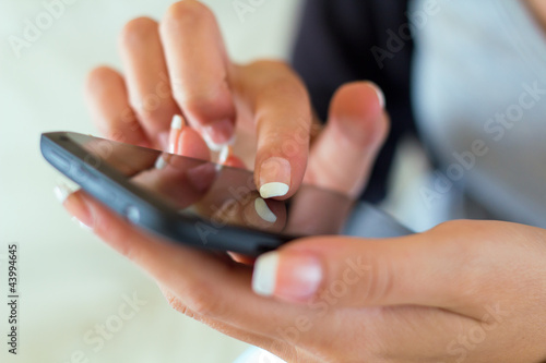 Photo: Girl hand touching screen on smart phone Girl hand touching screen on smart phone