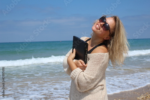 Photo: Beautiful blonde at the beach with laptop Beautiful blonde at the beach with laptop