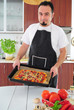 Foto: Young man in kitchen with homemade pizza Young man in kitchen with homemade pizza