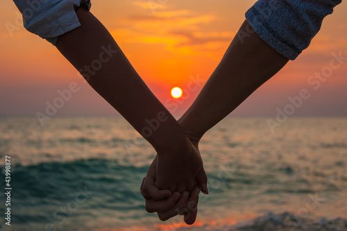 Photo: Couple Holding Hands at Sea Sunset Couple Holding Hands at Sea Sunset