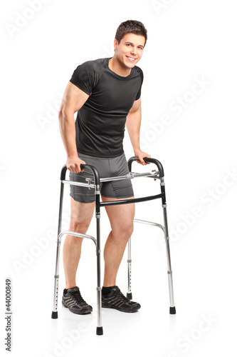 Photo: Full length portrait of a young smiling athlete using a walker Full length portrait of a young smiling athlete using a walker