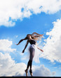 Foto: Ballerina dancing on the roof, clouds behind her Ballerina dancing on the roof, clouds behind her