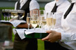 Waitress with dish of champagne glasses
