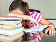 Tired schoolgirl sleeping on her desk (with books on it)
