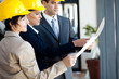 group of construction managers looking at blue print