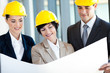 group of construction managers discussing project on blue print