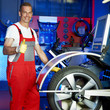 Master mechanic in a garage shows  thumb up for tyre fitting