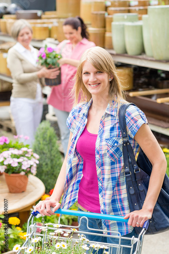 Photo: Woman with shopping cart in garden shop Woman with shopping cart in garden shop