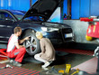 Foto: Female customer and mechanic checking the tyre of her car Female customer and mechanic checking the tyre of her car