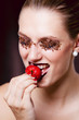 junge Frau mit Schokostreusel Makeup beißt in Erdbeere