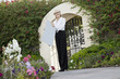 Photo: Portrait of a senior female real estate agent holding sign board in front of entrance gate Portrait of a senior female real estate agent holding sign board in front of entrance gate