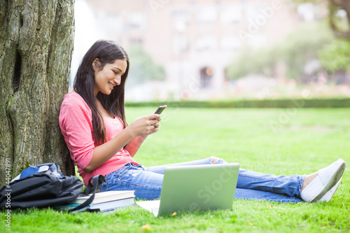 Photo: Hispanic college student texting Hispanic college student texting