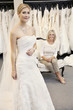 Foto: Portrait of a beautiful young woman in wedding dress with mother sitting background Portrait of a beautiful young woman in wedding dress with mother sitting background