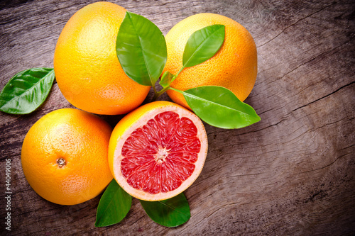 Photo: Freshly harvested grapefruit on wooden background Freshly harvested grapefruit on wooden background