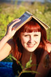 Photo: Young beautiful woman lays on green field and reads book. Young beautiful woman lays on green field and reads book.