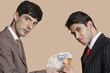Foto: Portrait of young businessmen showing Euros over colored background Portrait of young businessmen showing Euros over colored background