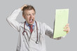 Male doctor terrified looking at medical reports over gray background