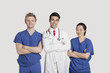 Photo: Portrait of multi ethnic healthcare professionals standing with arms crossed over gray background Portrait of multi ethnic healthcare professionals standing with arms crossed over gray background