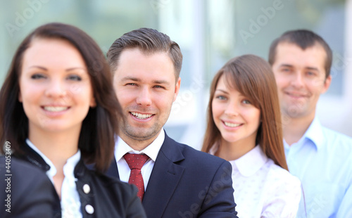 Photo: Happy smiling business team standing in a row at office Happy smiling business team standing in a row at office