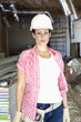 Portrait of beautiful young woman architect wearing hardhat at construction site