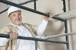 Portrait of mature man climbing scaffold