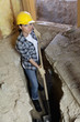 Portrait of female worker digging with shovel at construction site