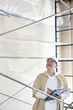 Photo: Male architect making a note in digital tablet pc while looking up at construction site Male architect making a note in digital tablet pc while looking up at construction site