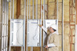 Photo: Male construction worker checking electric meters at construction site Male construction worker checking electric meters at construction site