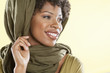 Foto: Happy African American woman with a stole over head looking away Happy African American woman with a stole over head looking away