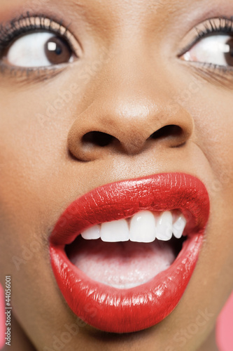 Photo: Cropped image of shocked young woman with red lips looking to her side Cropped image of shocked young woman with red lips looking to her side