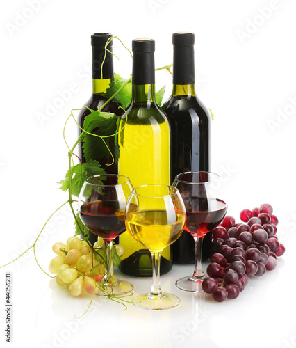 Photo: bottles and glasses of wine and ripe grapes isolated on white bottles and glasses of wine and ripe grapes isolated on white