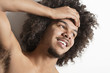 Close-up of a happy young man with hand on head over white background