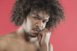 Portrait of young man with hand on chin over colored background