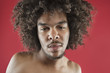 Close-up portrait of a young man with curly hair over colored background