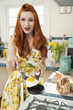 Portrait of a young redheaded woman cooking omelet