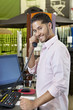 Photo: Portrait of a happy salesperson listening to telephone receiver in store Portrait of a happy salesperson listening to telephone receiver in store