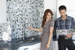 Young couple looking at color samples together in contemporary kitchen
