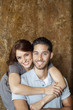 Portrait of happy young woman hugging man from behind