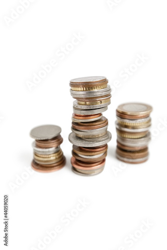 Photo: Close-up of stack of coins balancing over white background Close-up of stack of coins balancing over white background