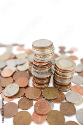 Photo: Close-up of heap of coins over white background Close-up of heap of coins over white background